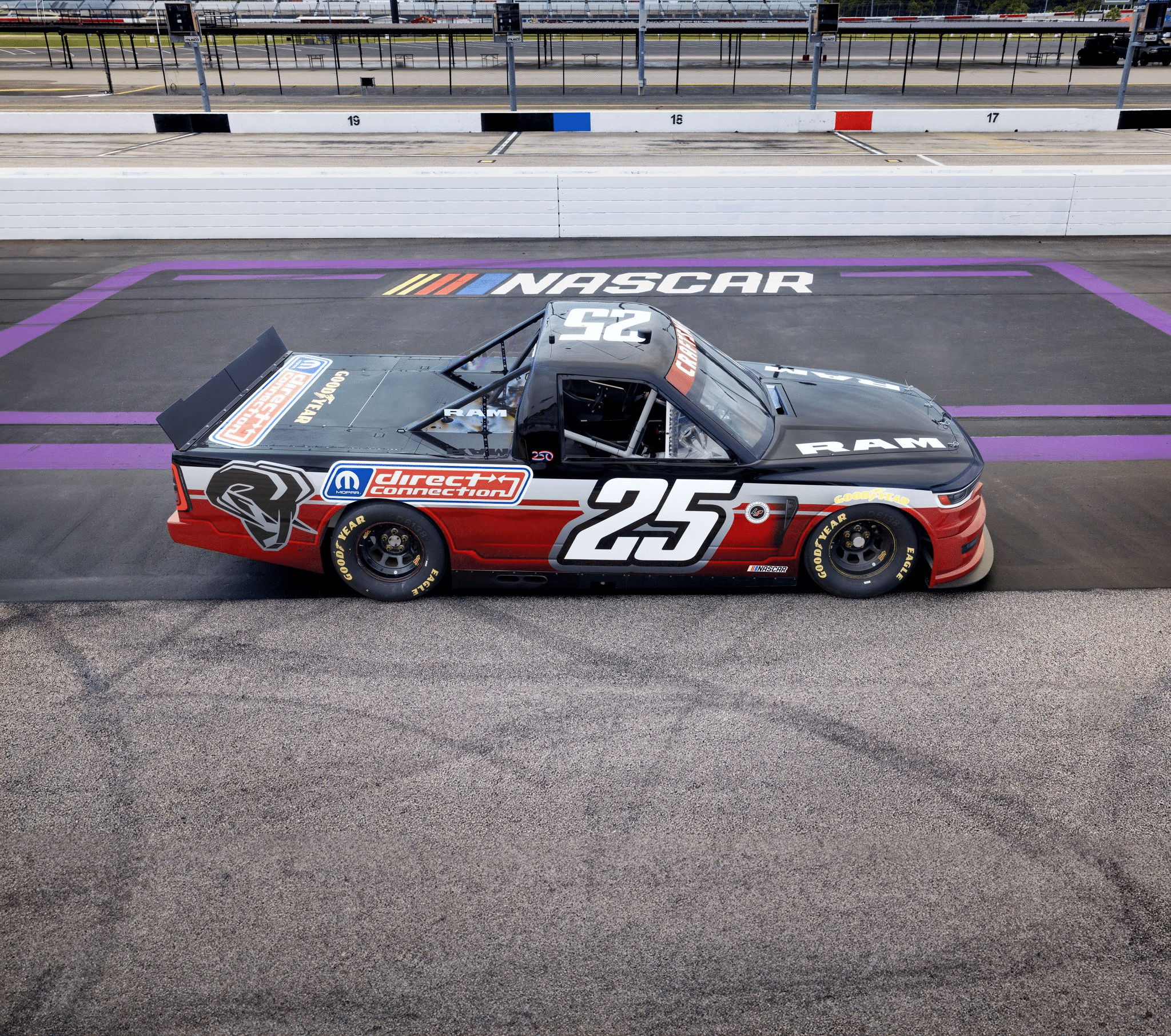 Un camion de course Ram n°25 sur la piste NASCAR, avec des logos visibles, dont 'direct connection'.